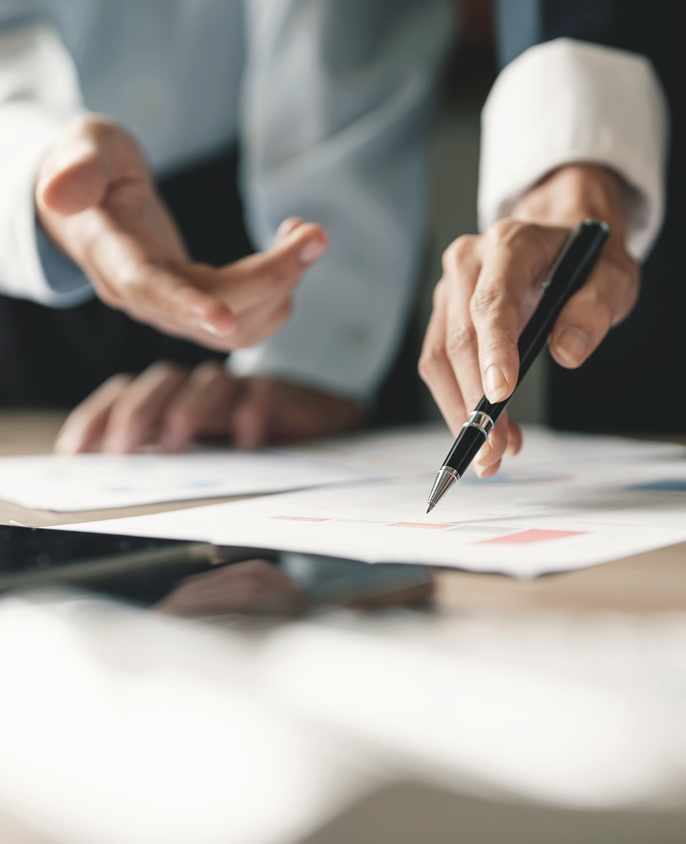 Zwei Hände zeigen auf Papiere, eine hält einen Stift - Jobs Immobilien Hamburg bei ALSTER-TERRAIN